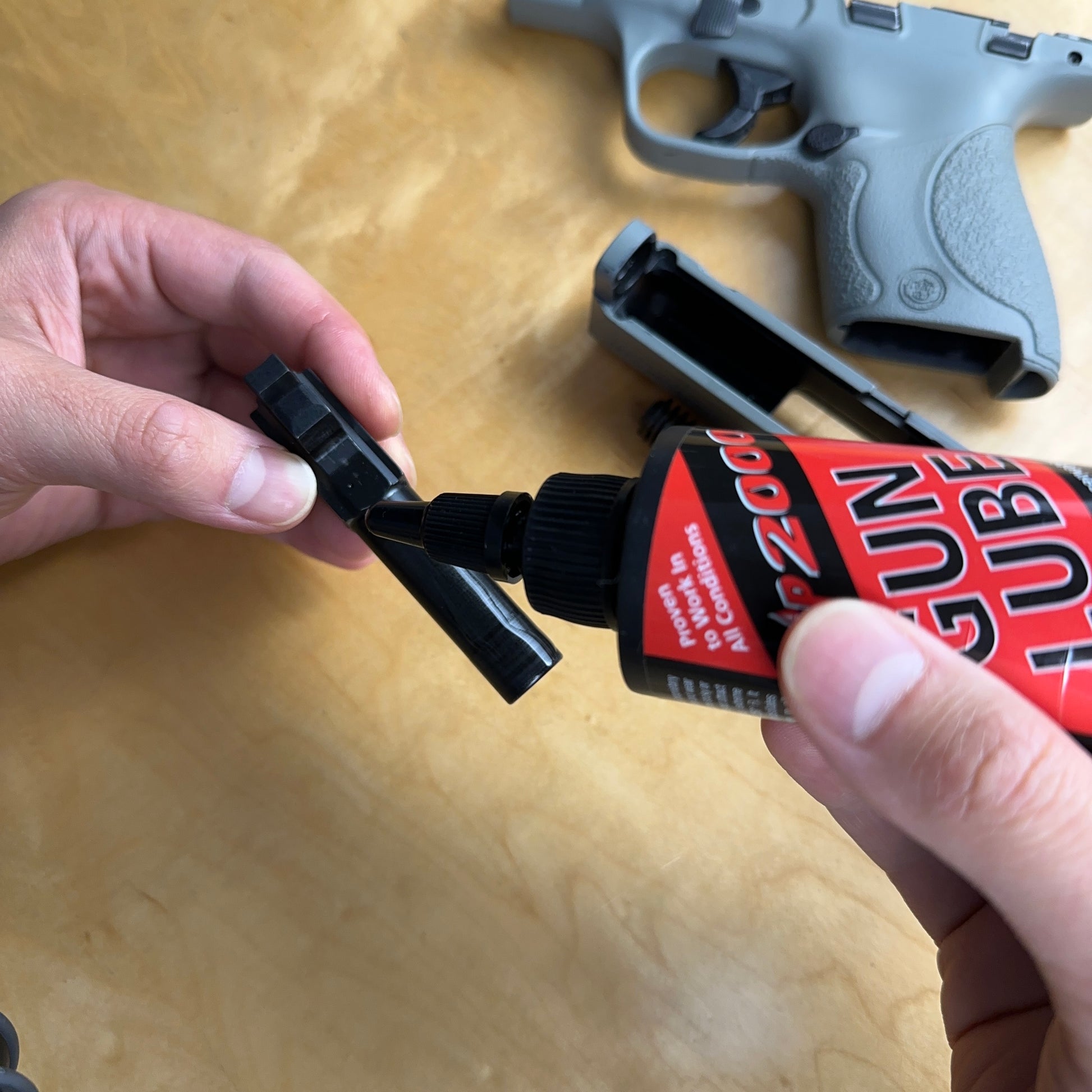 Slip 2000 Gun Lube being applied to a pistol barrel