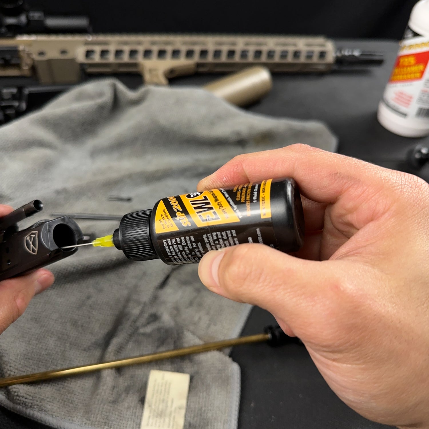 Slip 2000 EWL30 being used to oil the inside of a bolt carrier with a needle oiler tip
